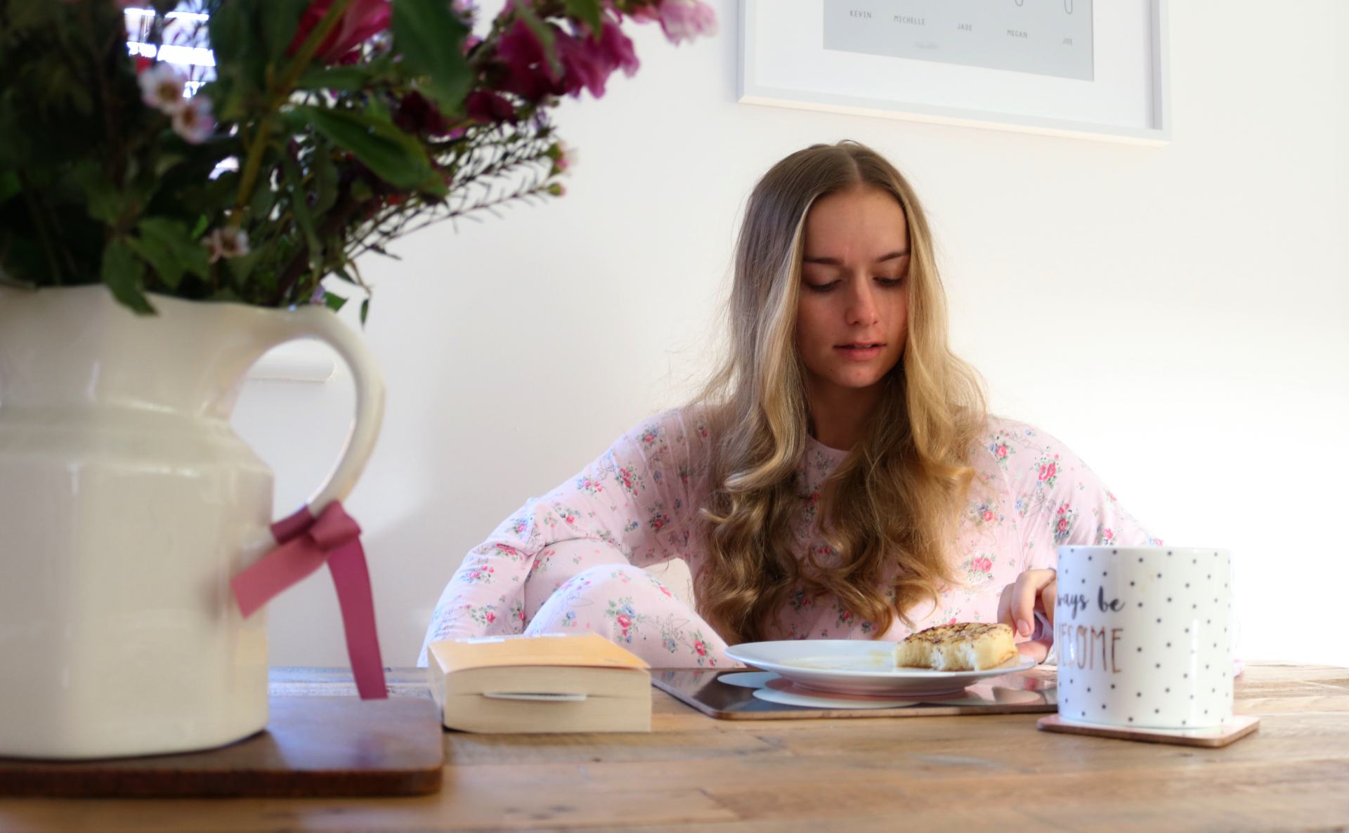 girl sat at table with breakfast